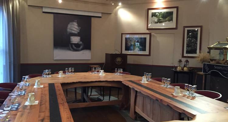 Configuración de sala de conferencias con mesas y vasos para degustación.