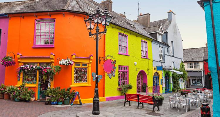 Row of brightly painted shopfronts and houses on a charming Irish street.
