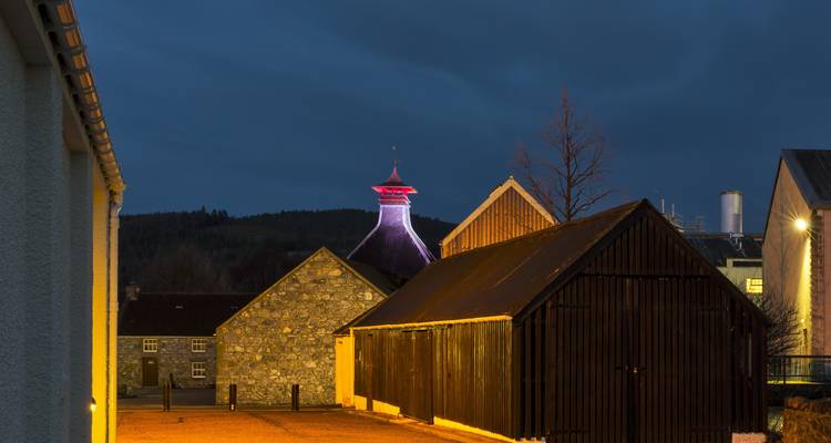 Bâtiment traditionnel de distillerie écossaise au crépuscule.
