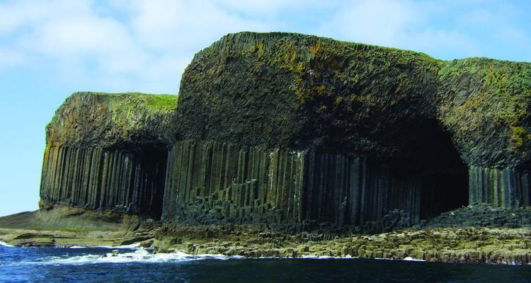 Les énormes colonnes de basalte hexagonales de la Grotte de Fingal s'élèvent des eaux de l'Atlantique.